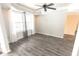 Well-lit living room with gray vinyl floors, a ceiling fan, and large windows providing ample natural light at 632 Middleham Cir, Beech Grove, IN 46107
