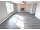 Bright living room features vinyl flooring, a ceiling fan, and a cozy fireplace with brick surround at 632 Middleham Cir, Beech Grove, IN 46107