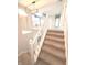 Carpeted stairs with white railings leading to a second-floor hallway with decorative lighting at 632 Middleham Cir, Beech Grove, IN 46107