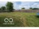 Fenced backyard with mature trees, offering privacy and space for outdoor activities at 6721 Jackson St, Anderson, IN 46013