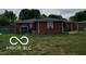 Spacious backyard showcasing the home's exterior with a covered patio at 6721 Jackson St, Anderson, IN 46013