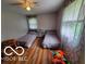 Bedroom featuring wood floors, two twin beds, and natural light at 6721 Jackson St, Anderson, IN 46013