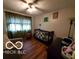 Brightly lit room with wood flooring, crib, and comfortable armchair at 6721 Jackson St, Anderson, IN 46013