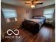 Bedroom with hardwood flooring, ceiling fan, and natural light from two windows at 6721 Jackson St, Anderson, IN 46013