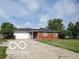 Charming single-story home featuring a red brick facade, attached garage, and well-manicured front lawn at 6721 Jackson St, Anderson, IN 46013