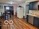 Open concept kitchen with stainless steel dishwasher, light countertops, and wood look flooring at 6721 Jackson St, Anderson, IN 46013