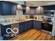 Updated kitchen features stainless steel appliances, granite counters, and ample cabinet storage at 6721 Jackson St, Anderson, IN 46013