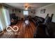 Cozy living room with hardwood floors, a ceiling fan, and large windows at 6721 Jackson St, Anderson, IN 46013