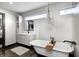 Stylish bathroom features a freestanding tub, chandelier, modern vanity, and framed mirror at 7143 W 50 S, Morgantown, IN 46160