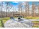 Enjoy this outdoor fire pit and seating area that's perfect for gathering and relaxation surrounded by trees at 7143 W 50 S, Morgantown, IN 46160