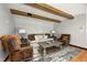 Comfortable living room with exposed beams, a neutral sofa, stylish chairs, and a decorative rug create a cozy atmosphere at 7143 W 50 S, Morgantown, IN 46160