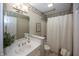 Traditional bathroom with large mirror, shower with curtain, white vanity, and floral wallpaper border at 7195 Koldyke Dr, Fishers, IN 46038