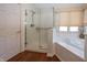 Modern bathroom features a glass-enclosed shower, soaking tub, and a bright window at 7195 Koldyke Dr, Fishers, IN 46038
