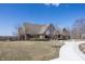 Brick home exterior with mature trees, manicured lawn, and circular driveway entrance at 7195 Koldyke Dr, Fishers, IN 46038