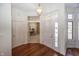 Bright foyer with hardwood floors and view into a home office, illuminated by a stylish pendant light at 7195 Koldyke Dr, Fishers, IN 46038
