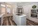 Well-lit kitchen island cooktop, dining area, and built-in oven at 7195 Koldyke Dr, Fishers, IN 46038