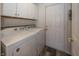 Functional laundry room with washer, dryer, cabinets, door, and wood-look flooring at 7195 Koldyke Dr, Fishers, IN 46038