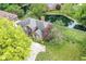 Aerial view of a home with a pond, lush trees, manicured landscaping and a stamped concrete driveway at 7645 Ballinshire N, Indianapolis, IN 46254