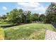 Landscaped backyard with black metal fencing around a pond, and a brick paver walkway at 7645 Ballinshire N, Indianapolis, IN 46254