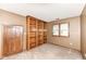 Bedroom with a built-in bookcase, a window, and neutral walls, offering a space for relaxation and reading at 7645 Ballinshire N, Indianapolis, IN 46254