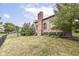 Backyard view highlighting the brick home's architectural details, landscaping, and well-maintained lawn at 7645 Ballinshire N, Indianapolis, IN 46254