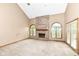 Living room with a brick fireplace, light colored carpet, and natural light at 7645 Ballinshire N, Indianapolis, IN 46254