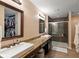 Main bathroom featuring double sinks, granite countertops, walk-in shower, and a spacious walk-in closet at 7675 Winding Lake S Dr, Noblesville, IN 46062