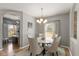 Cozy dining room with modern lighting, neutral decor, and an archway to another room at 7675 Winding Lake S Dr, Noblesville, IN 46062