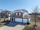 View of a charming two-story home featuring a brick and vinyl facade and a two-car garage at 7675 Winding Lake S Dr, Noblesville, IN 46062