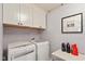 Convenient laundry room with modern washer and dryer, and stylish wallpaper at 7675 Winding Lake S Dr, Noblesville, IN 46062