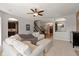 Bright and open living room with a ceiling fan, stairs, and archways to other rooms at 7675 Winding Lake S Dr, Noblesville, IN 46062