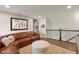 Spacious living room has a comfortable leather sofa, neutral colors, and view of the staircase at 7675 Winding Lake S Dr, Noblesville, IN 46062