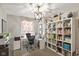 A well-organized office space with a large bookshelf, desk, and ample natural light at 7675 Winding Lake S Dr, Noblesville, IN 46062