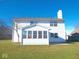 The back of the white two-story home features an enclosed sunroom extension with multiple windows at 777 West St, Whiteland, IN 46184