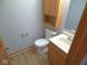 Bathroom with a single sink vanity, wood-look flooring, and a classic toilet at 777 West St, Whiteland, IN 46184