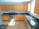 Well-lit kitchen features wooden cabinets, sleek black countertops, and stainless-steel appliances at 777 West St, Whiteland, IN 46184