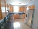 Spacious kitchen with wooden cabinets, a stainless steel refrigerator, and a view of the yard at 777 West St, Whiteland, IN 46184