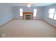 Large living room featuring a fireplace with a decorative mantel, neutral carpet, and lots of light at 777 West St, Whiteland, IN 46184