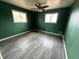 View of bedroom with green walls and gray wood flooring at 8328 S Franklin Rd, Indianapolis, IN 46259