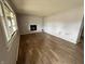 Empty living room featuring light gray walls, wood flooring, and a cozy fireplace at 8328 S Franklin Rd, Indianapolis, IN 46259