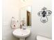 Cozy powder room featuring a pedestal sink, decorative mirror, and modern fixtures at 936 Plunkett Ave, Westfield, IN 46074