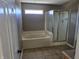 A full bathroom featuring a shower and tub combo with tile walls and a large window at 9808 Worthington Blvd, Fishers, IN 46038