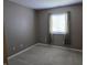 Bedroom with neutral carpeting and paint, featuring a window with curtains and a view of outdoors at 9808 Worthington Blvd, Fishers, IN 46038