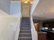 Foyer with carpeted stairs, views to the kitchen, and lots of natural light at 9808 Worthington Blvd, Fishers, IN 46038