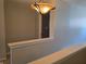 Upper hallway with a decorative light fixture with an open doorway to another room at 9808 Worthington Blvd, Fishers, IN 46038