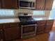 Kitchen featuring stainless steel appliances, dark cabinets, and stone countertops at 9808 Worthington Blvd, Fishers, IN 46038