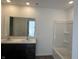 Bathroom with a double sink vanity, large mirror, and a combined bathtub and shower at 10265 Cliff Ln, Indianapolis, IN 46239