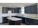 Well-lit kitchen featuring dark cabinetry, a large sink under the window, and a functional island at 10265 Cliff Ln, Indianapolis, IN 46239
