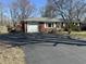 Red brick ranch-style home with attached garage and long asphalt driveway at 1031 Schleicher Ave, Indianapolis, IN 46229