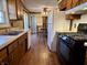 Galley kitchen with laminate wood flooring, stainless sink, white appliances, and dark cabinetry at 1031 Schleicher Ave, Indianapolis, IN 46229